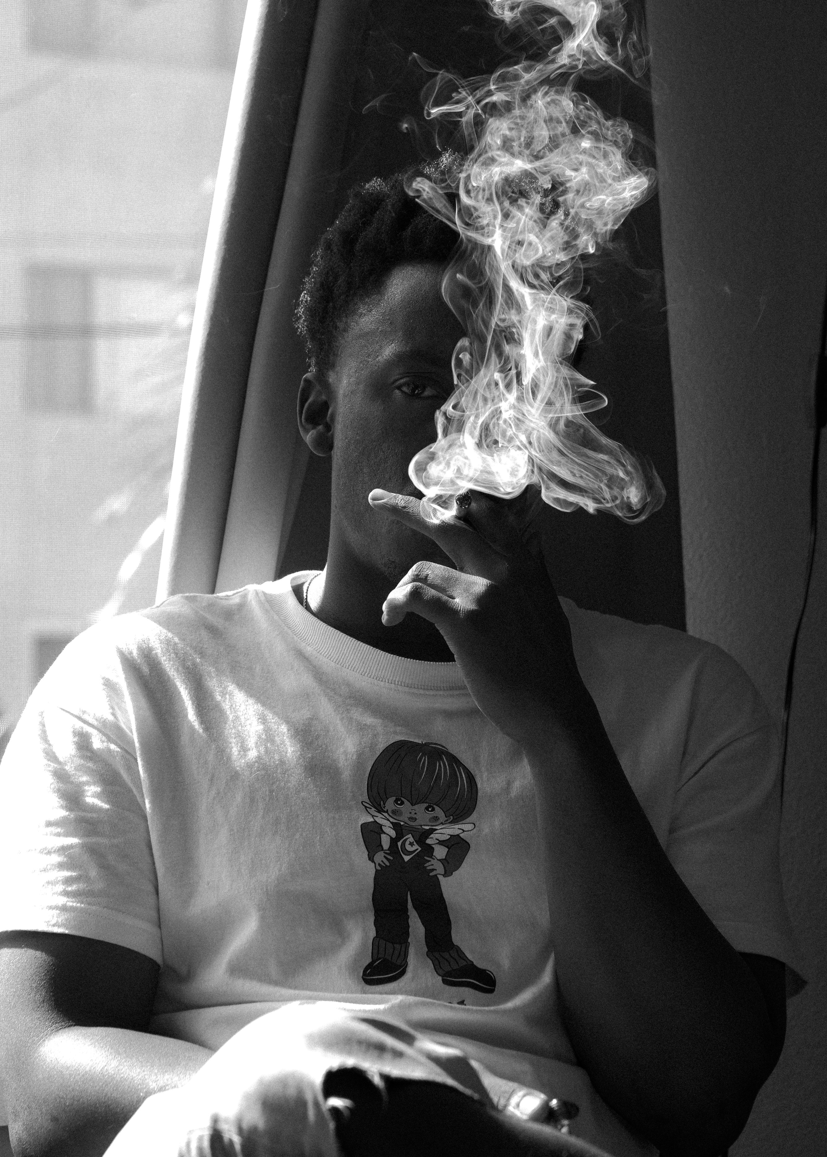 man in crew neck t-shirt smoking cigarette